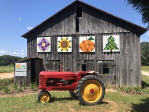 farmall tractor in front of an old tobacco barn