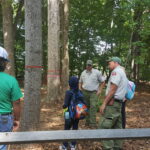 Forest Rangers teach youth participants how to identify a tree.