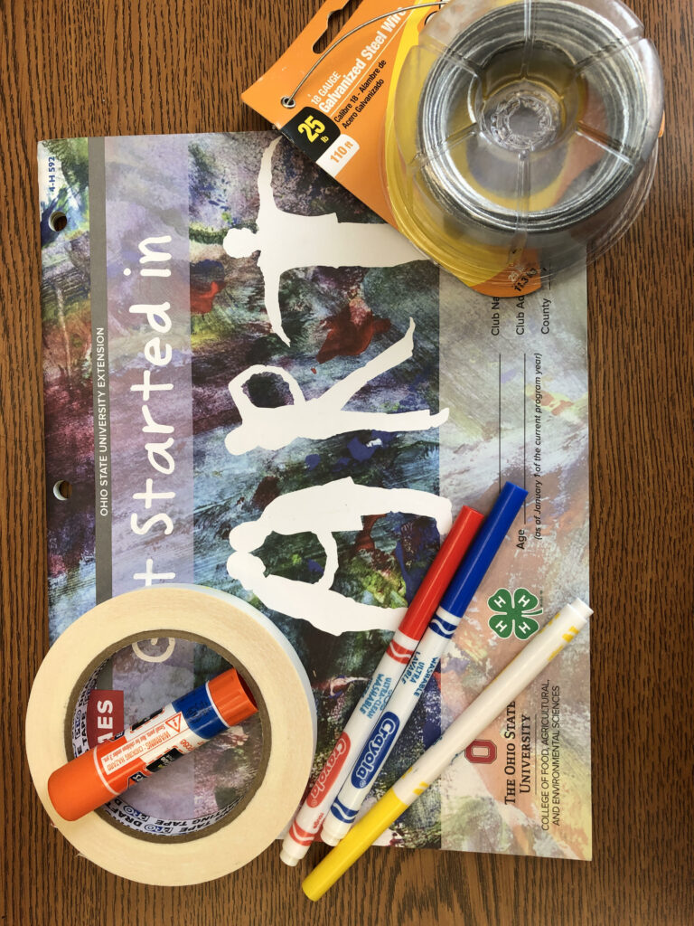 Craft supplies, markers and steel wire on a wooden table.