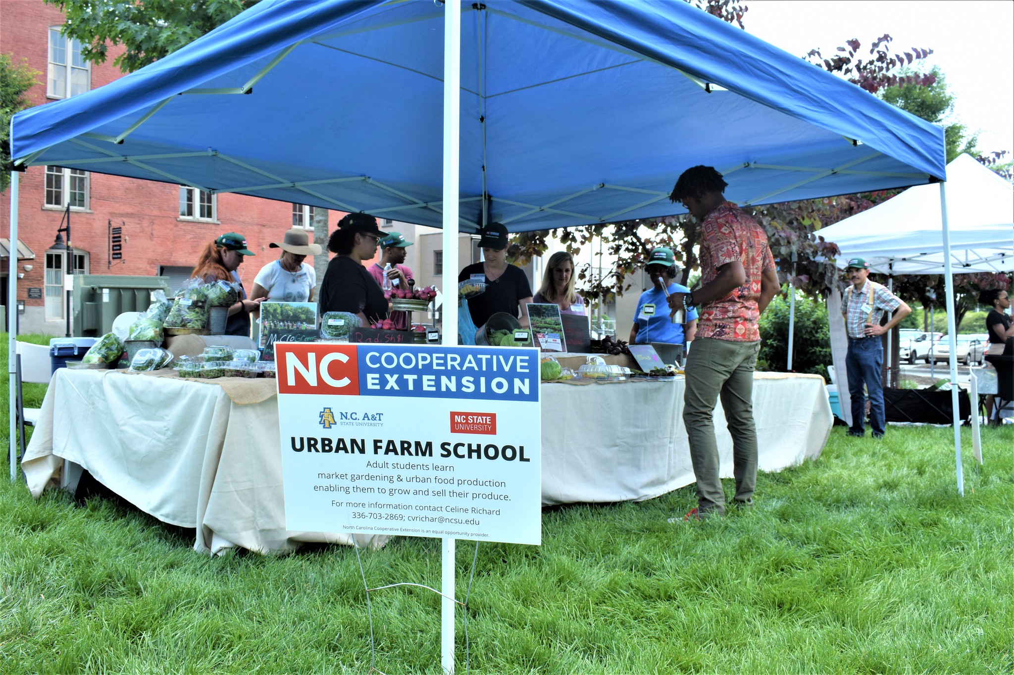 A young man inspects the Urban Farm School tent.